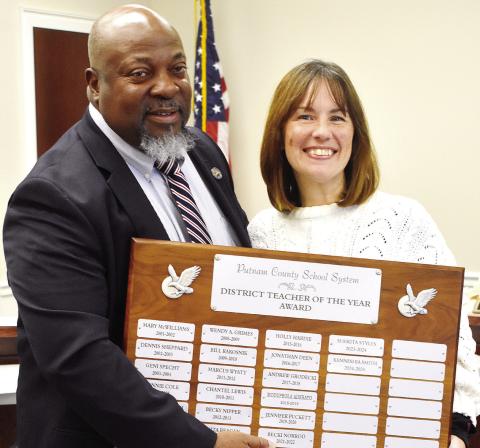 District Teacher of the Year Sharon Creek, alongside Superintendent Derick Austin, holds up the Teacher of the Year plaque, where her name will soon be engraved. BAILEY BALLARD/Staff
