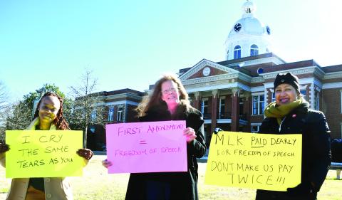 Karen Garrett (right) organized a small but heartfelt demonstration Monday morning in Martin Luther King Jr.’s memory on the Putnam County Courthouse lawn in downtown Eatonton. IAN TOCHER/Staff