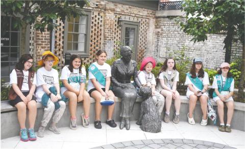 Posing with a statue of Girl Scouts of the USA founder Juliette Gordon Low in the front yard at Low’s birthplace in Savannah, are members of Girl Scouts of Eatonton (l-r): Zoey Robinson, Elizabeth Hensley, Karmen Spillers, Sophia Talavera, Victoria Hensley, Raegan Ogden, Tegan Rainey, and Stormy Kendrick. LENA HENSLEY/Staff