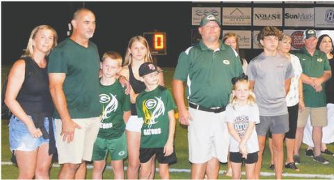 Chris Daniluk (second from left) and Clyde Harper (sixth in line) gathered with their families and friends at halftime during the Gatewood football game last Friday night, where the practice facility they built for the school was dedicated in memory of Harper’s nephew, Walt Harper. CONTRIBUTED
