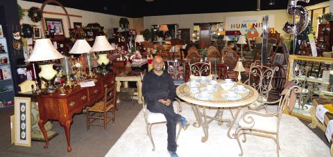 Putnam HFH Executive Director Murali Thiramul sits amidst the crowded showroom of furniture and housewares at the current Habitat Restore on Lake Oconee Parkway.
