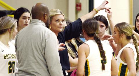 Gatewood head coach Jordan Walters steals a look at the scoreboard while counseling her Lady Gators during a recent game timeout. IAN TOCHER/Staff