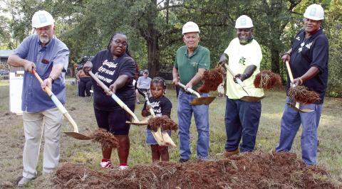 Helping to toss the ceremonial first shovelfuls of dirt alongside Standish Avenue was Putnam County Commission Chairman Bill Sharp (left), beside soon-to-be homeowner Tawana Ellison and her four-year-old daughter Gracelyn. IAN TOCHER/Staff
