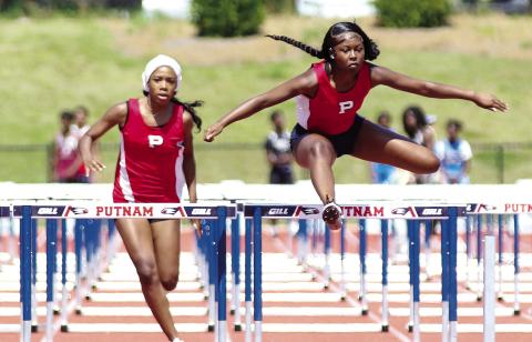 Putnam County’s Kamryn Manning and Malaya Robinson compete in the 300 hurdles event during the Region 4-AA meet in late April. TREY NORRIS/Staff