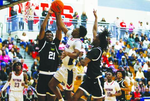 Putnam County’s Jmari Greene goes up for a layup but is met by two Greenforest defenders who attempt to block his shot. LANCE McCURLEY/Staff