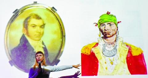 Mauriel Joslyn stands in front of the slide showing two portraits of Alexander McGillivray, the one on the right being a sketch by John Trumbull depicting him as an Indian Chief.