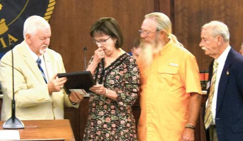 Retiring Senior Personal Property Appraiser Leisa Reid reacts to receiving an official Putnam County proclamation recognizing her 48 years of service to the county from Chairman Bill Sharp prior to last Friday’s county commission meeting. IAN TOCHER/Staff