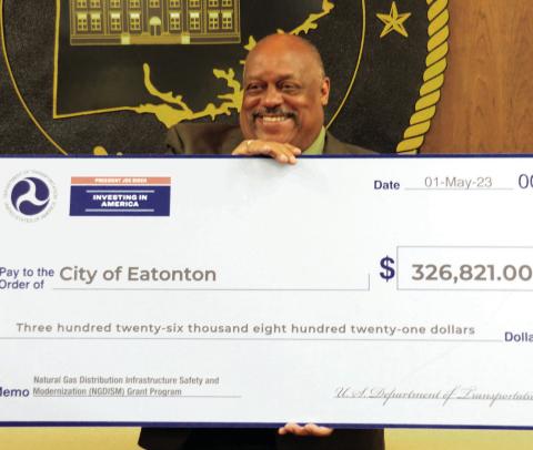 Following the May 7 city council meeting, Eatonton Mayor John Reid posed with a symbolic $326,821 check from the U.S. Dept. of Transportation as part of its Natural Gas Distribution Infrastructure Safety and Modernization grant program, intended to help cities and municipalities replace aging and deteriorating natural gas delivery systems. Reid said he greatly appreciates the help from federal authorities to advance Eatonton’s ongoing modernization efforts. IAN TOCHER/Staff