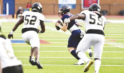 Putnam quarterback Branan Griffin tries to get the ball away quickly as Greene County defensive linemen Dayshaun Copeland (52) and Jamarion Evans (59) are in hot pursuit. BRENDAN KOERNER/Staff