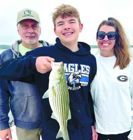 Tom, Evan and Monica Wehman with Evan’s first striper from Lake Sinclair. CONTRIBUTED