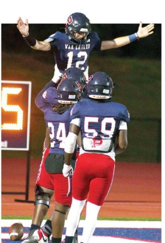 War Eagles quarterback Ethan Whatley is hoisted high above the end zone by teammates Friday night after scoring his first of five touchdowns just 44 seconds into the game against Utopian Academy. IAN TOCHER/Staff