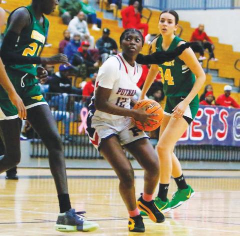 Putnanm sophomore Eriyana Little (12) makes her way through the way trying to attempt a layup over a Greenforest defender. LANCE McCURLEY/Staff