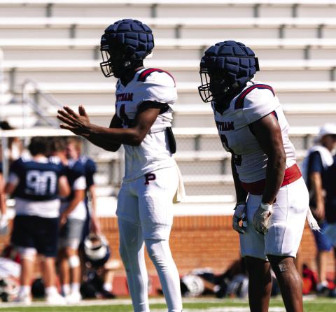 Putnam County quarterback Caleb Reeves (left) gets set to take a snap from the shotgun formation during the team’s padded camp in Eatonton on July 16. JCVISUALS/Contributed