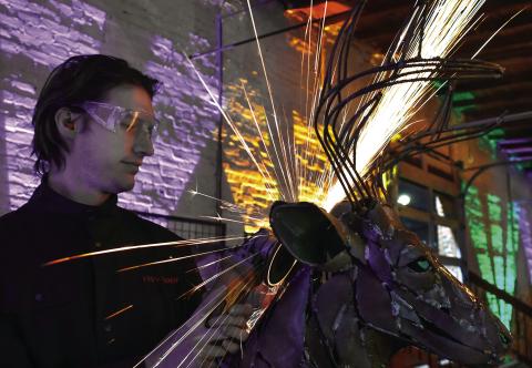 Sparks fly as noted Lake Country metal sculptor Brian Dawson works on a sculpture during the 6th annual Artigras event last Saturday night at The Livery in downtown Eatonton. IAN TOCHER/Staff
