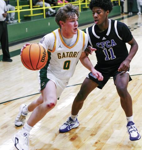 Gatewood’s Bennett Haley (0) attempts to drive the ball inside the lane past a Central Fellowship Christian defender in a 56-50 loss to the Lancers on Jan. 13. IAN TOCHER/Staff