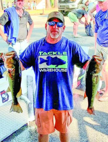Lance Collins shows off two of the bass that helped him finish on top in the United in Pink Tournament. CONTRIBUTED