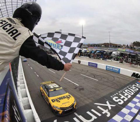 Christopher Bell, driver of the No. 20 DeWalt Toyota, takes the checkered flag to win the Cup Series Xfinity 500 at Martinsville Speedway Sunday. (Mike Mulholland/Getty Images)
