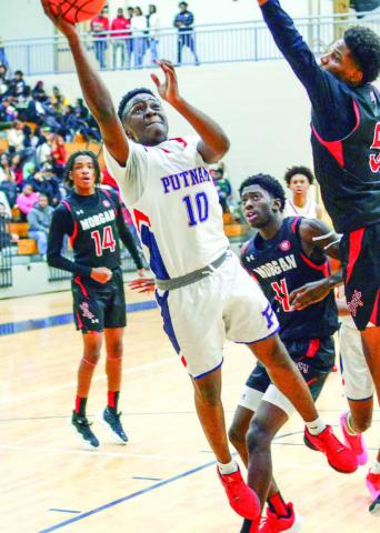Putnam County’s Tamaud Woodson (10) attempts to make a layup over a Morgan County defender in last week’s win over the Dogs. IAN TOCHER/Staff