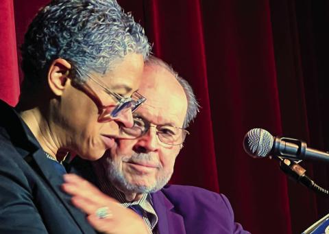 With Larry Moore by her side, Rebecca Walker is emotionally taken by seeing her father’s handwritten inscription inside the front cover of her mother Alice Walker’s first book, a collection of poems published in 1968. IAN TOCHER/Staff