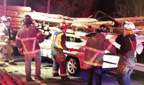 Eatonton Fire Department first responders work to rescue a driver trapped in an SUV after crashing into a log truck Monday. CONTRIBUTED/EPD