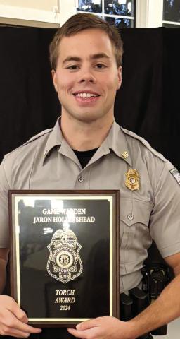 Game Warden Jaron Hollinshead poses with the 2024 Georgia Level Torch Award. (CONTRIBUTED)