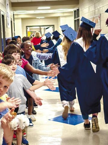 Seniors walk down the hall of Putnam County Elementary School and high five students as they pass by. CONTRIBUTED