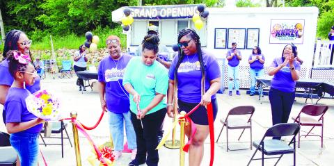 Surrounded by friends, family and well-wishers, Anfrankina “Kina” Little (center) cuts the ribbon to officially open Kina’s Krazy Kreations, her new roadside restaurant alongside Hwy. 44 on Eatonton’s south side. IAN TOCHER/Staff