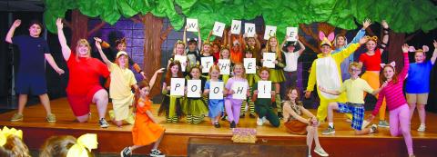 Gatewood Players show off the final scene of the play, holding up letters spelling out the name of the performance. LENA HENSLEY/Staff