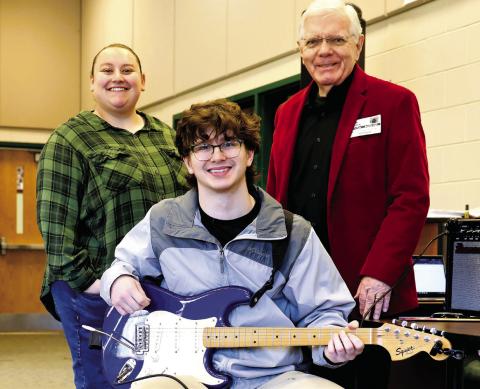 Baldwin High School music teacher Robyn Meeks, Milledgeville First Methodist Church music minister John Cotton, and Baldwin High School student Kyle Camilla pose for the Putnam Christian Outreach Angel Tree presentation of a Fender Squire Stratocaster electric guitar. CONTRIBUTED