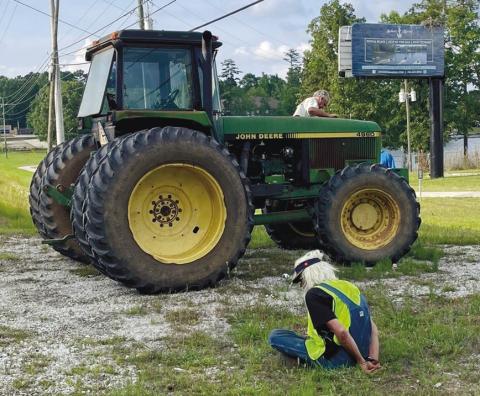 Paul Matthew Kroening sits handcuffed beside the tractor he is accused of stealing as the tractor’s owner, Tim Camp, checks it out. Sheriff Howard Sills pulled the tractor over on Lake Oconee Parkway near Anchors Marina. CONTRIBUTED