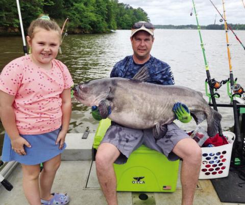 Guy Covington and his young daughter show off the record-setting 79.5-pound catfish he caught last month near Oconee Springs Park on Lake Sinclair. Georgia Outdoor News