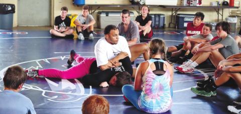 Bryce Carr with help from Tristan Lower demonstrates hold for wrestlers. ARELLA CASH/Staff