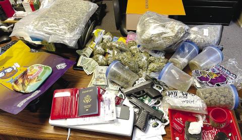 Five pounds marijuana packaged for selling, powder cocaine, handguns, cash, vape pens, a passport, and other items pictured were seized by local authorities last week. CONTRIBUTED