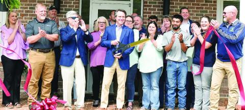 Piedmont Water owner Adam Shaifer (center) cuts the ribbon for the company’s Customer Care and Learning Center April 15 as employees, the Eatonton-Putnam Chamber of Commerce, Greene County Chamber of Commerce, and community members celebrate. HANNAH BARRON Staff