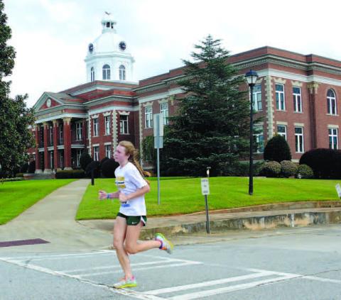 Court date: Gatewood 10th grade student Ansleigh Hillin, 15, runs past the historic Putnam County courthouse in downtown Eatonton before eventually finishing as the womens’ class winner of Gatewood’s annual Swamp Stomp 5K. IAN TOCHER/Staff