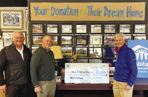 Chaplain Doug Turner (left) and Mike Rowland from Grove Chapel Ministries recently presented a $6,450 check to Putnam County Habitat for Humanity Board Chair Bucky Kahl (right), for the construction of two new roofs on current house builds on South Madison Avenue in Eatonton. This cumulative gift from community members at Grove Chapel helps lower the cost of construction for the affiliate, which translates to greater impact in the Putnam County community. CONTRIBUTED