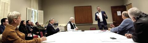 Joel Wiggins (standing), managing partner of the Southern Group of Georgia and a representative of the C-PACE Alliance, addresses members of the Lake Oconee Area Development Authority last Thursday at Farmers &amp; Merchants Bank on Lake Oconee Parkway. Melody Echols, program administrator with Peach State C-PACE, is seated at left. IAN TOCHER/Staff