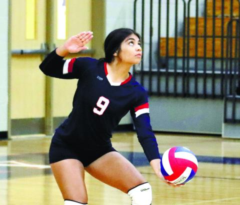 Leslya Arriola (9) gets ready to set up a serve.