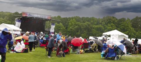 Mother Nature brought strong winds and heavy rain, which changed the program, but the show still went on as attendees huddled under umbrellas and bundled up in rain coats to brace for the elements.