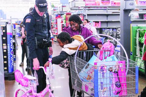 Athena Hall, 5, demonstrates the music player on her new bicycle for Officer Chris Detweiler. JEREMY MCCLURE/Contributed