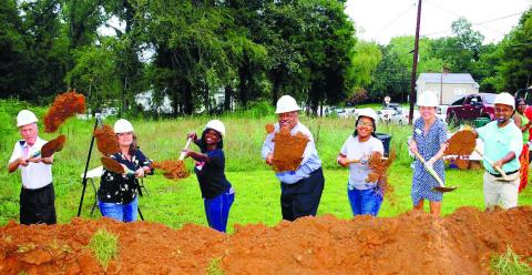 IAN TOCHER/Staff Flanked by soon-to-be new homeowners and Habitat for Humanity representatives, including Putnam County Habitat Executive Director Murali Thirumal (far right) and Eatonton Mayor John Reid (center).