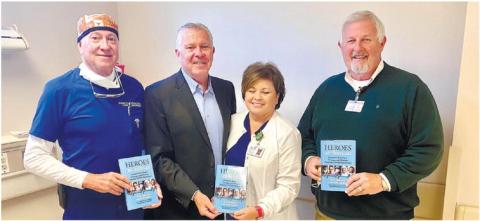 Putnam General Hospital urologist Bob Cowles, author Bob Delaney, Pam Douglas and PGH CEO Alan Horton display copies of Delaney’s new book, Heroes are Human. CONTRIBUTED