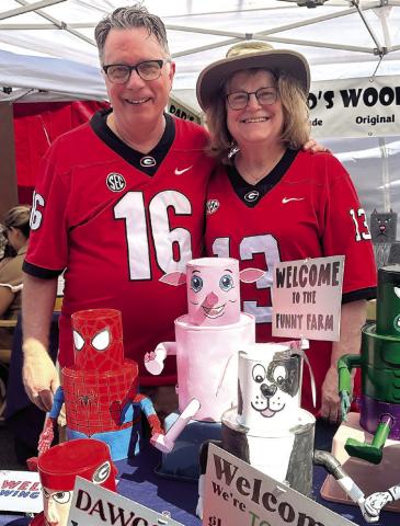 Allan and Julie Dodson show off their art sold at “Dad’s Woodshed.” They were one of 80 registered artisans at the market. ALIVIA BLANTON/ Staff