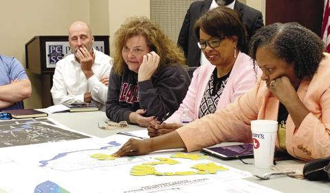 Board members test designs on the in-scale map while discussing budgetary concerns and the site. BAILEY BALLARD/Staff