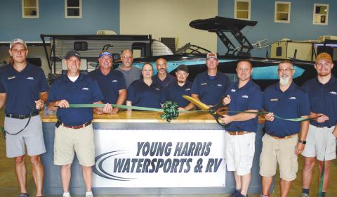 Surrounded by employees new and old, Young Harris Watersports and RVs owner Lance Markham prepares to cut the ribbon. IAN TOCHER/Staff