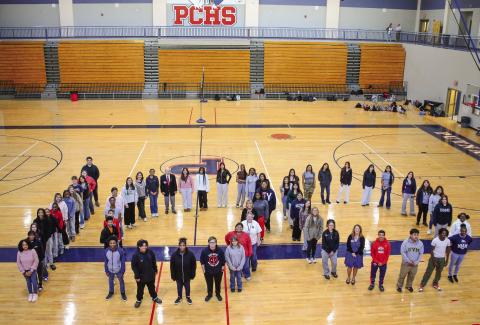 Members of the Putnam County High School Key Club, including President Carolyn Thomas (in pink, back of center “0”) pay tribute to the Eatonton Kiwanis’ 100th year of service to local communities. IAN TOCHER/Staff