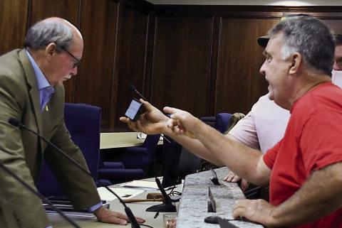 Local landowner Mark Thompson (right) addresses Putnam County Planning &amp; Zoning Commissioner Charles Gray at the end of a tumultuous meeting March 5, as another citizen shows Gray a document on his phone. IAN TOCHER/Staff