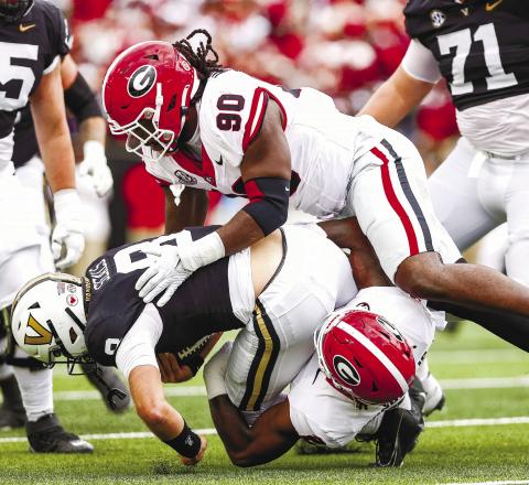 Georgia defensive lineman Tramel Walthour (90) and inside linebacker Smael Mondon Jr. (2) tackle Vanderbilt quarterback Ken Seals (8) during Saturday’s TONY WALSH/UGA Athletics game in Nashville.