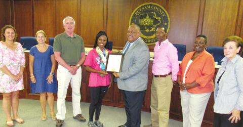 Putnam County High School rising sophomore and award-winning gymnast Karmyn Manning is presented a plaque by Eatonton Mayor John Reid and the City Council at their July 5 meeting. A proclamation read by Reid congratulated her for placing first All Around in her age group at the AAU Gymnastics National Championship in Springfield, Ill., earlier this month. MARK ENGEL/Staff