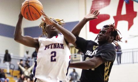 Putnam County senior guard Landon Bonner (2) goes up for a layup against Greene County junior forward RJ Monford. LANCE MCCURLEY/Staff